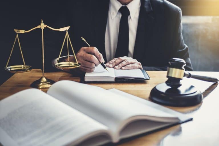 Male lawyer or judge working with contract papers, Law books and