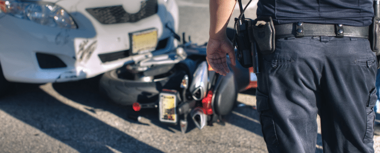 A police officer standing in front of a car accident