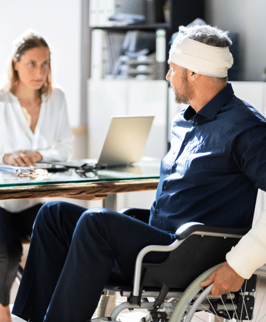 A disabled person in a wheelchair talking with a disability worker