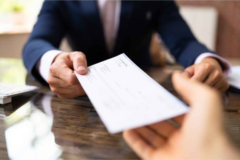 employer handing a workers' compensation benefits check to an injured worker