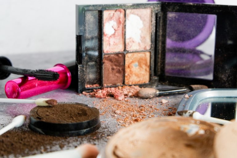 Old, dried-up eyeshadow, foundation, and mascara spilled out onto countertop.